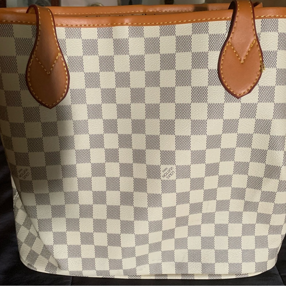 Knock off Never Full Never used plastic still on handles. Comes with wristlet